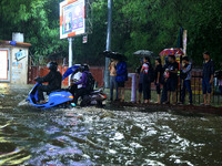 Vehicles and locals are moving through the waterlogged road at Narayan Singh Circle following heavy monsoon rains, in Jaipur, Rajasthan, Ind...