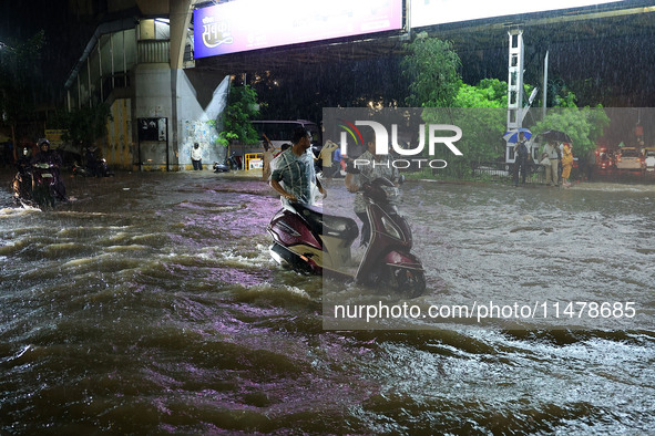 Vehicles are moving through the waterlogged road at Narayan Singh Circle following heavy monsoon rains in Jaipur, Rajasthan, India, on Wedne...