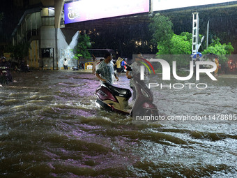 Vehicles are moving through the waterlogged road at Narayan Singh Circle following heavy monsoon rains in Jaipur, Rajasthan, India, on Wedne...