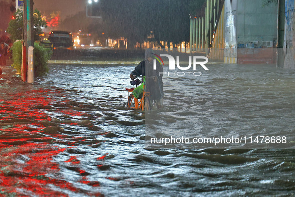 Locals are moving through the waterlogged road at Narayan Singh Circle following heavy monsoon rains, in Jaipur, Rajasthan, India, on August...