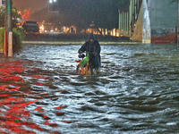 Locals are moving through the waterlogged road at Narayan Singh Circle following heavy monsoon rains, in Jaipur, Rajasthan, India, on August...