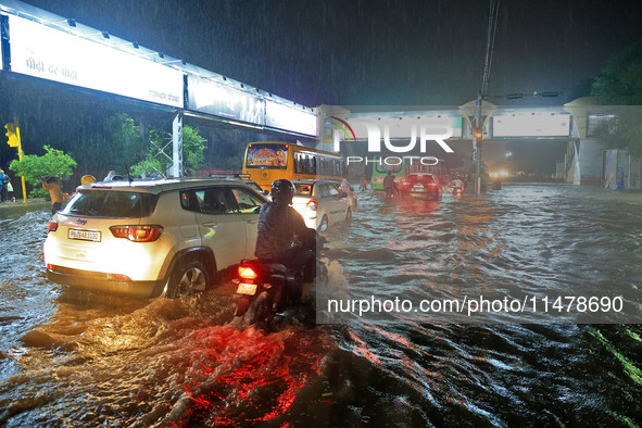 Vehicles are moving through the waterlogged road at Narayan Singh Circle following heavy monsoon rains in Jaipur, Rajasthan, India, on Wedne...