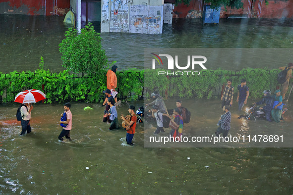 Vehicles and locals are moving through the waterlogged road at Narayan Singh Circle following heavy monsoon rains, in Jaipur, Rajasthan, Ind...