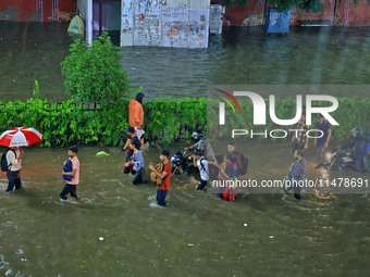 Vehicles and locals are moving through the waterlogged road at Narayan Singh Circle following heavy monsoon rains, in Jaipur, Rajasthan, Ind...