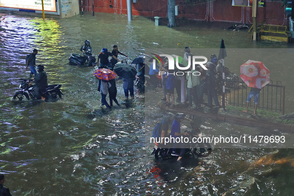 Vehicles and locals are moving through the waterlogged road at Narayan Singh Circle following heavy monsoon rains, in Jaipur, Rajasthan, Ind...