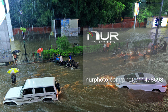 Vehicles and locals are moving through the waterlogged road at Narayan Singh Circle following heavy monsoon rains, in Jaipur, Rajasthan, Ind...