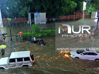 Vehicles and locals are moving through the waterlogged road at Narayan Singh Circle following heavy monsoon rains, in Jaipur, Rajasthan, Ind...