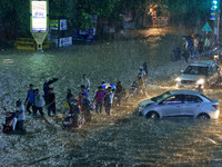 Vehicles and locals are moving through the waterlogged road at Narayan Singh Circle following heavy monsoon rains, in Jaipur, Rajasthan, Ind...