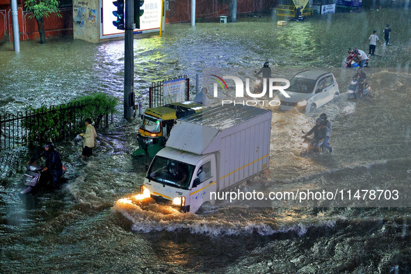 Vehicles are moving through the waterlogged road at Narayan Singh Circle following heavy monsoon rains in Jaipur, Rajasthan, India, on Wedne...