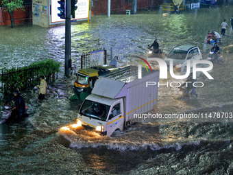 Vehicles are moving through the waterlogged road at Narayan Singh Circle following heavy monsoon rains in Jaipur, Rajasthan, India, on Wedne...