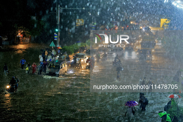 Vehicles and locals are moving through the waterlogged road at Narayan Singh Circle following heavy monsoon rains, in Jaipur, Rajasthan, Ind...