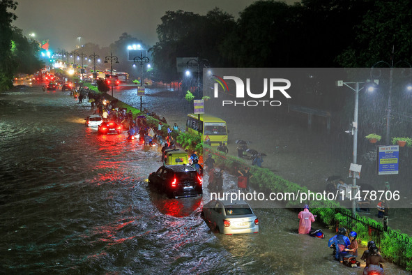 Vehicles and locals are moving through the waterlogged road at Narayan Singh Circle following heavy monsoon rains, in Jaipur, Rajasthan, Ind...