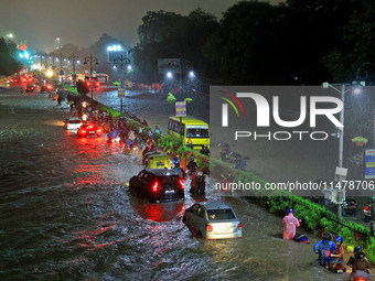 Vehicles and locals are moving through the waterlogged road at Narayan Singh Circle following heavy monsoon rains, in Jaipur, Rajasthan, Ind...