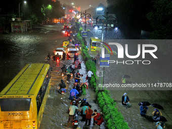 Vehicles are moving through the waterlogged road at Narayan Singh Circle following heavy monsoon rains in Jaipur, Rajasthan, India, on Wedne...