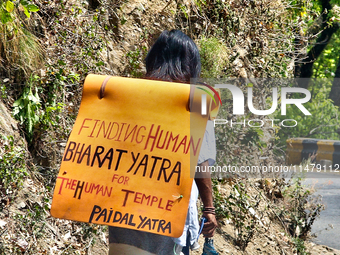 A man is walking as he takes part in the Paidal Yatra for the Human Temple in Kathgodam, Uttarakhand, India, on April 21, 2024. (