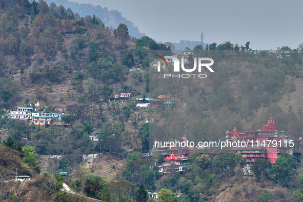 Hindu temples and other buildings are lining the mountainside in Kathgodam, Uttarakhand, India, on April 21, 2024. Kathgodam is a suburb of...