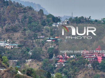 Hindu temples and other buildings are lining the mountainside in Kathgodam, Uttarakhand, India, on April 21, 2024. Kathgodam is a suburb of...