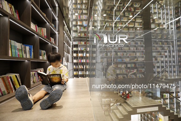 A child is reading at Boya Bookstore in Zixing, China, on August 12, 2024. 