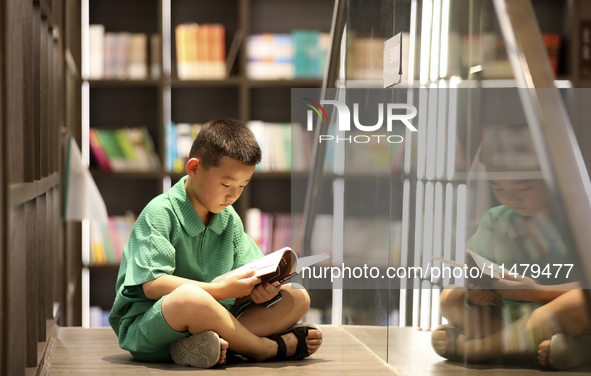 A child is reading at Boya Bookstore in Zixing, China, on August 12, 2024. 