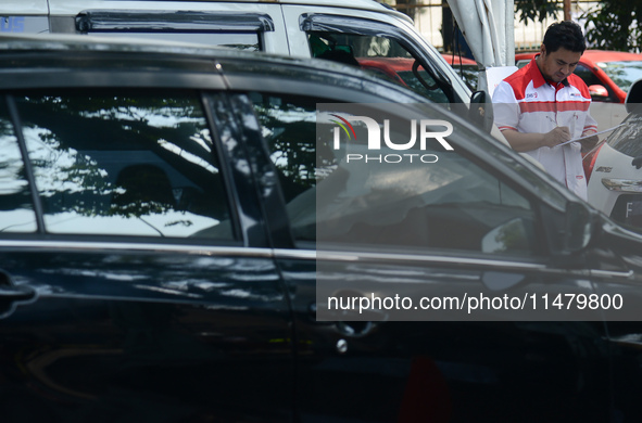 An officer is writing down notes during emission testing at one of the emission test locations in Bogor, West Java, Indonesia, on August 15,...