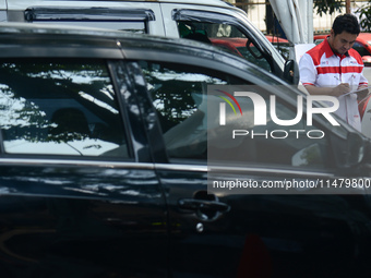 An officer is writing down notes during emission testing at one of the emission test locations in Bogor, West Java, Indonesia, on August 15,...