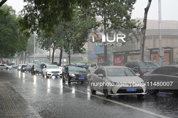 Vehicles and pedestrians are making their way through the rain on the East Third Ring Road in Beijing, China, on August 15, 2024. 