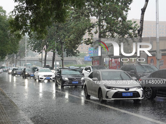 Vehicles and pedestrians are making their way through the rain on the East Third Ring Road in Beijing, China, on August 15, 2024. (