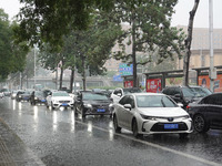 Vehicles and pedestrians are making their way through the rain on the East Third Ring Road in Beijing, China, on August 15, 2024. (