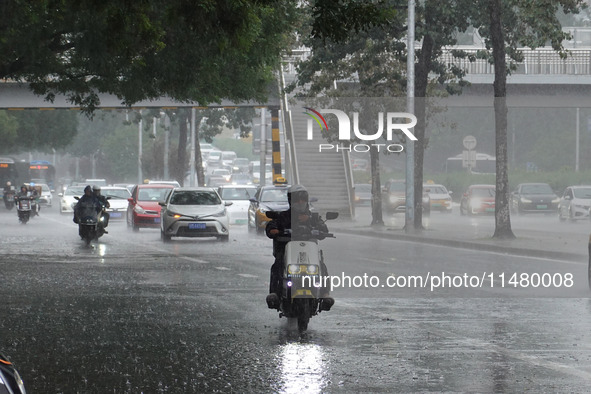 Vehicles and pedestrians are making their way through the rain on the East Third Ring Road in Beijing, China, on August 15, 2024. 