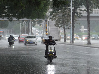 Vehicles and pedestrians are making their way through the rain on the East Third Ring Road in Beijing, China, on August 15, 2024. (