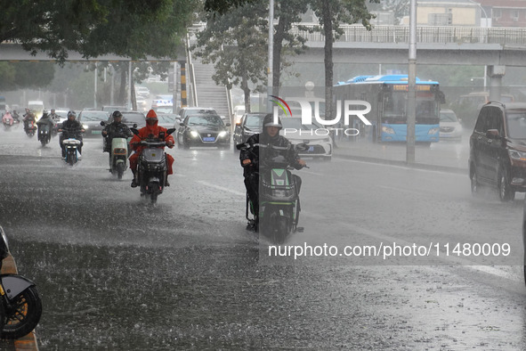 Vehicles and pedestrians are making their way through the rain on the East Third Ring Road in Beijing, China, on August 15, 2024. 