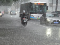 Vehicles and pedestrians are making their way through the rain on the East Third Ring Road in Beijing, China, on August 15, 2024. (