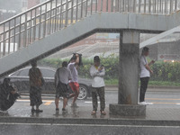 Pedestrians are taking shelter from the rain at the East Third Ring Road in Beijing's Chaoyang district in Beijing, China, on August 15, 202...