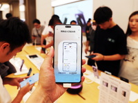 Visitors are shopping for a Huawei Mate60 mobile phone that supports Beidou satellite calls at the Huawei flagship store in Shanghai, China,...