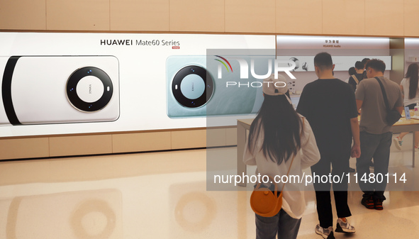 Visitors are shopping for a Huawei Mate60 mobile phone that supports Beidou satellite calls at the Huawei flagship store in Shanghai, China,...