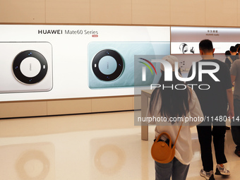 Visitors are shopping for a Huawei Mate60 mobile phone that supports Beidou satellite calls at the Huawei flagship store in Shanghai, China,...