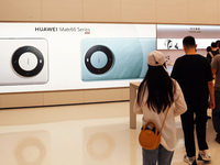 Visitors are shopping for a Huawei Mate60 mobile phone that supports Beidou satellite calls at the Huawei flagship store in Shanghai, China,...