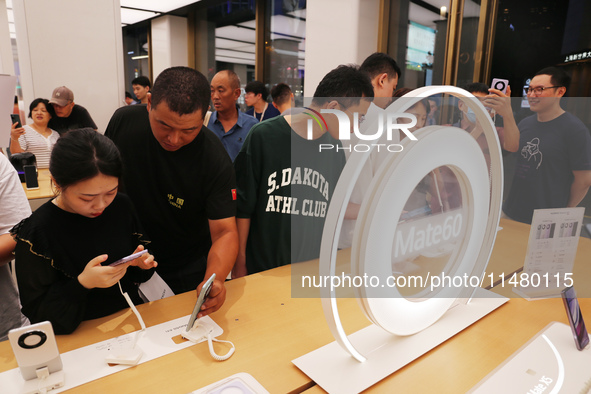 Visitors are shopping for a Huawei Mate60 mobile phone that supports Beidou satellite calls at the Huawei flagship store in Shanghai, China,...