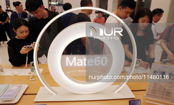 Visitors are shopping for a Huawei Mate60 mobile phone that supports Beidou satellite calls at the Huawei flagship store in Shanghai, China,...