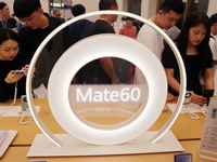 Visitors are shopping for a Huawei Mate60 mobile phone that supports Beidou satellite calls at the Huawei flagship store in Shanghai, China,...