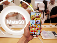 Visitors are shopping for a Huawei Mate60 mobile phone that supports Beidou satellite calls at the Huawei flagship store in Shanghai, China,...