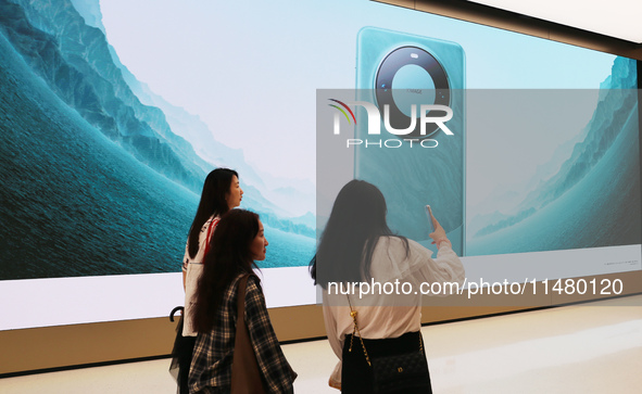 Visitors are shopping for a Huawei Mate60 mobile phone that supports Beidou satellite calls at the Huawei flagship store in Shanghai, China,...