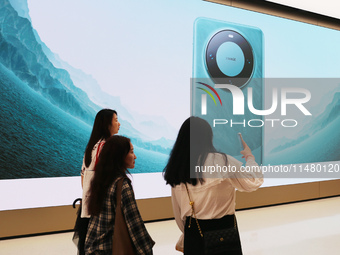 Visitors are shopping for a Huawei Mate60 mobile phone that supports Beidou satellite calls at the Huawei flagship store in Shanghai, China,...