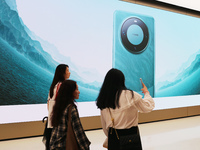 Visitors are shopping for a Huawei Mate60 mobile phone that supports Beidou satellite calls at the Huawei flagship store in Shanghai, China,...