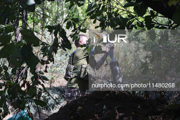 A serviceman of the 24th King Daniel of Galicia Separate Mechanized Brigade is loading a mortar while firing at the positions of Russian tro...