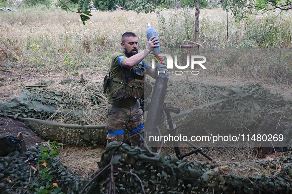 A serviceman of the 24th King Daniel of Galicia Separate Mechanized Brigade is loading a mortar while firing at the position of Russian troo...