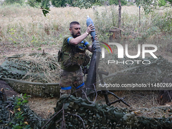 A serviceman of the 24th King Daniel of Galicia Separate Mechanized Brigade is loading a mortar while firing at the position of Russian troo...