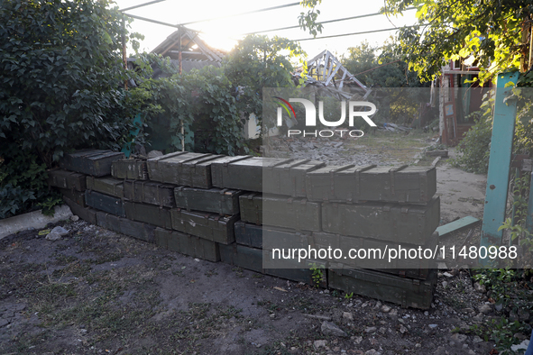 Abandoned Russian ammunition boxes are being stacked in the yard house in Kamianka village, Kharkiv region, which is being destroyed by Russ...