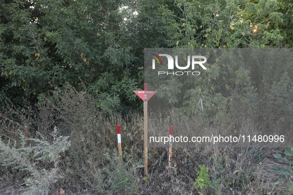 The 'Danger! Mines!' sign is standing in Kamianka village, Kharkiv region, Ukraine, on August 14, 2024, which was destroyed by Russian troop...