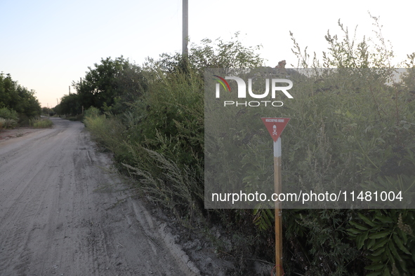 The 'Danger! Mines!' sign is standing in Kamianka village, Kharkiv region, Ukraine, on August 14, 2024, which was destroyed by Russian troop...